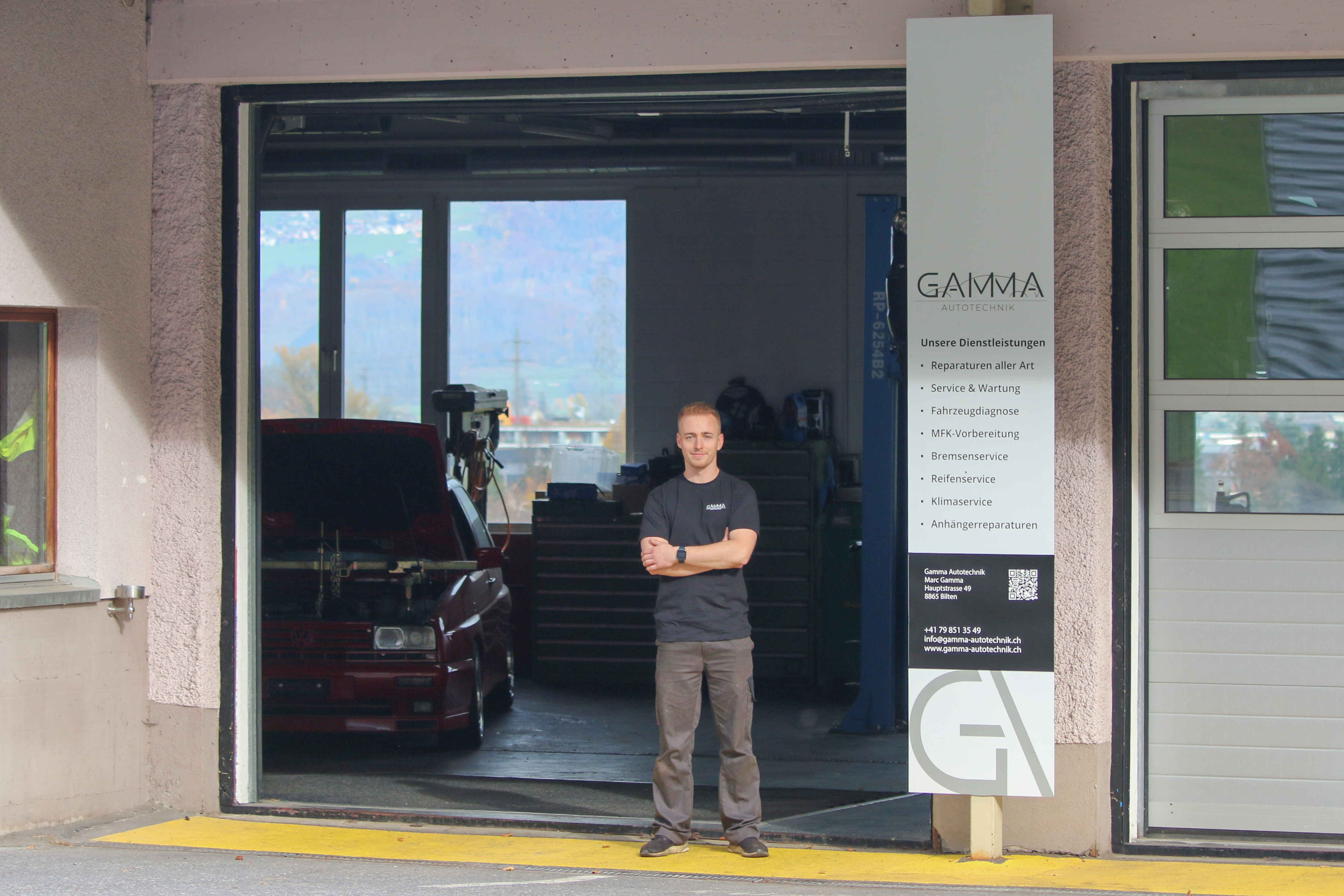 Marc Gamma steht vor dem offenen Garagentor der Gamma Autotechnik